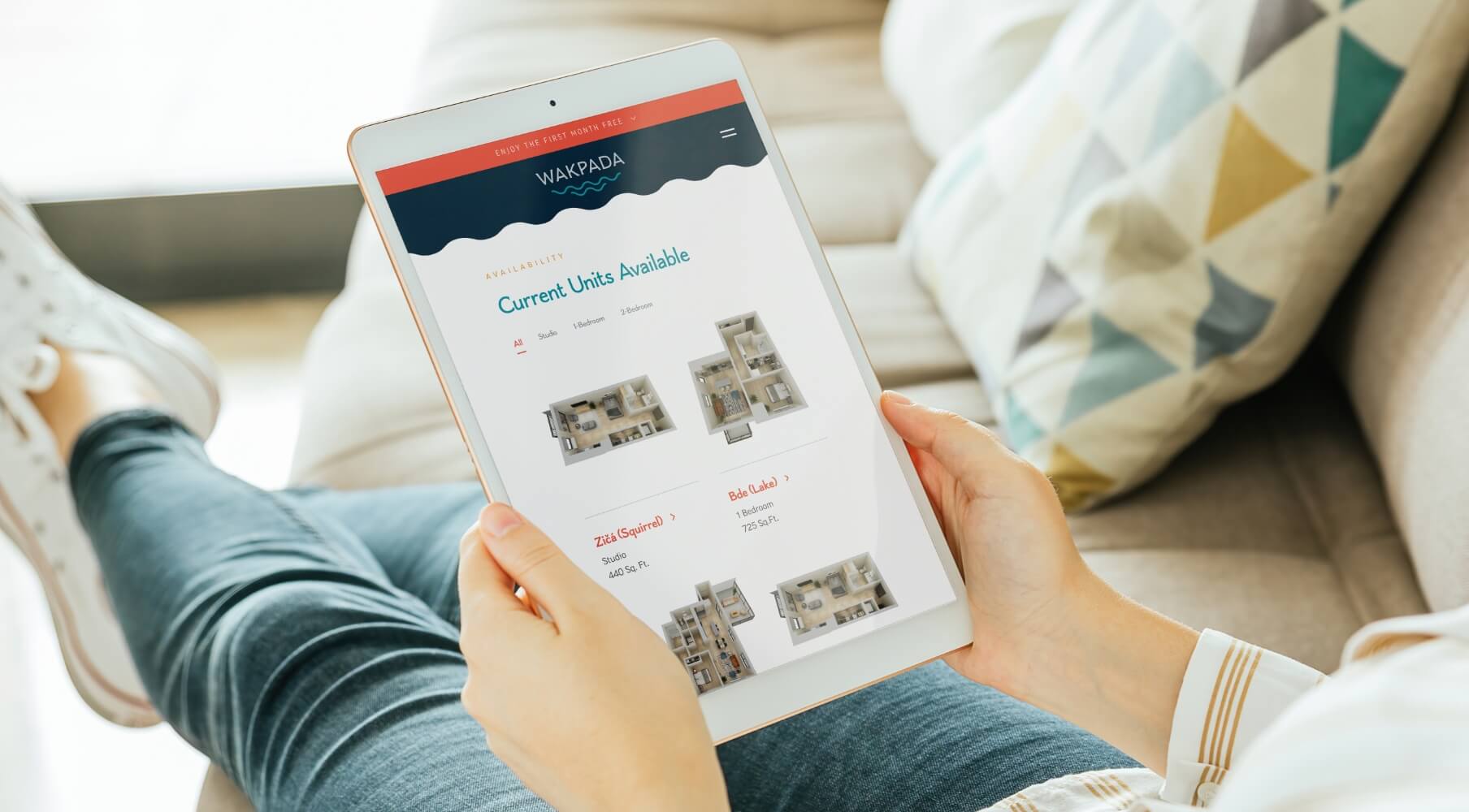 a woman with her feet up on the couch looking at the wakpada website on her tablet